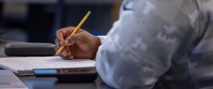 Student taking notes in class. 