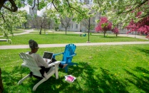 A student work on a laptop outside on South Campus. 