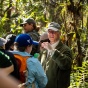 student looking at salamander in hands with a head lamp. 