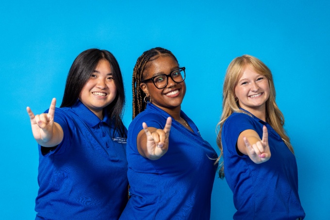 College Ambassadors making the "horns up" hand sign. 