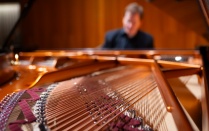 Zoom image: Eric Huebner plays the Department of Music's new Bösendorfer piano in Slee Hall in February 2024. Photographer: Douglas Levere