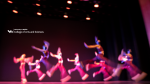 Zoom image: Blurry dance performers dancing on a stage with the College of Arts and Sciences logo.