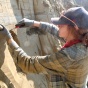MA Student Kayla Hollister removes sediments from a wall near Fairbanks, Alaska. 