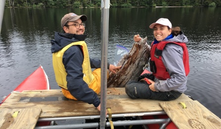 Two students examining a submerged tree. 