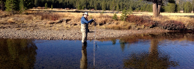 A faculty member collecting samples in a lake. 