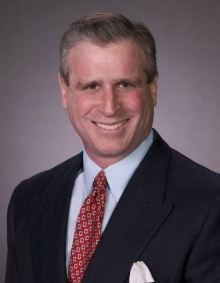 Alumnus Barry Kaplan, headshot with grey backdrop. 