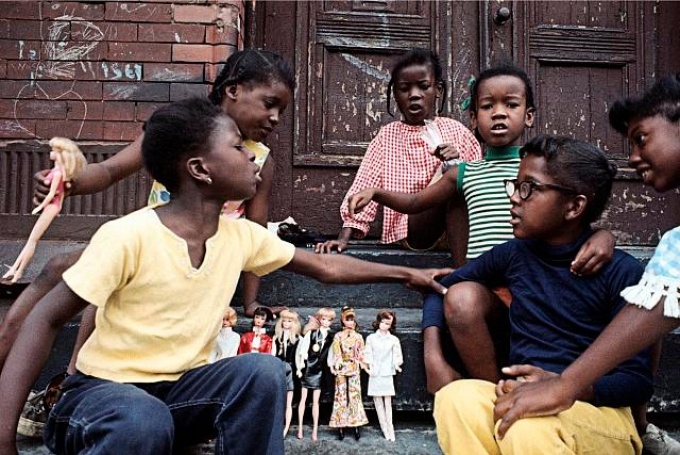 African American children with dolls sitting on a stoop. 