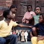 African American children with dolls sitting on a stoop. 