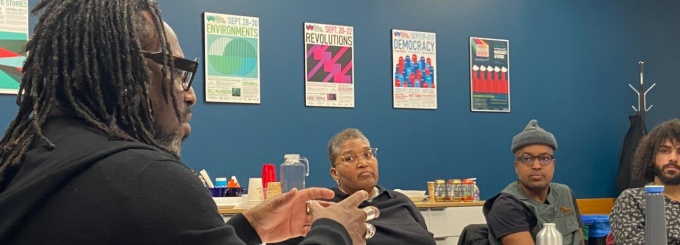 Rinaldo Walcott seated at a conference table with New Faculty Seminar attendees during their 2023-24 session. 