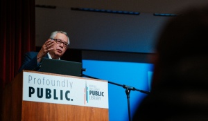 Photo portrait of journalist Juan Gonz&aacute;lez standing at podium while speaking. 