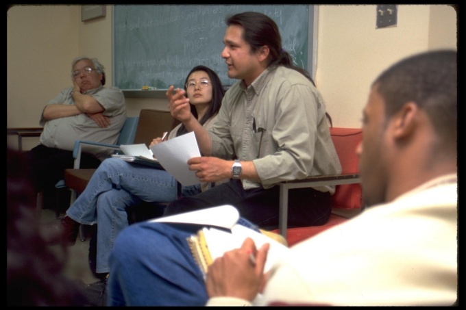 Four people sitting in chairs having a conversation. 