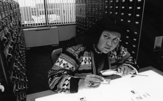 A faculty member in their office looking at slides. 