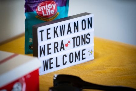 A white rectangular sign with black letters on it that welcomes students to a space. 