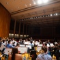 A concert band holds a dress rehearsal on the stage in Slee Hall. 