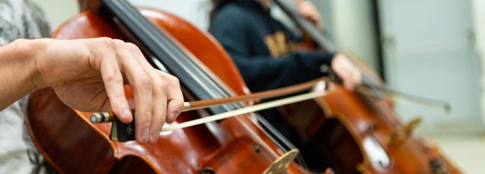 A closeup of a student playing the cello. 