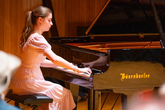 A Brown Bag Concert, a regular series showcasing the students and faculty in the Department of Music, held on the stage in Lippes Concert Hall in Slee Hall in March 2024. Music performance student Aria McKee plays the new Bösendorfer piano. Photographer: Douglas Levere. 