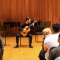 A student performing a guitar solo on stage during a Brown Bag Concert. 