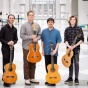 Six guitar players pose in the atrium of the Center for the Arts. 