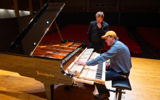 Devin Zimmer, the piano technician, works with the Department of Music's new Bösendorfer piano in Slee Hall. 