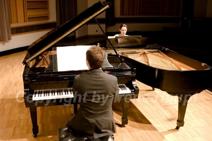 Two Performance Institute Members playing piano. 