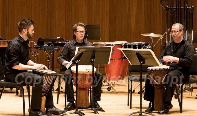 3 performers playing "Okho". 