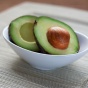 Bowl with a cut avocado. 