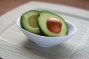 Bowl with a cut avocado. 
