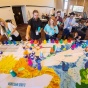 Workshop attendees participate in a mapping activity using tall colorful cups. 
