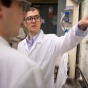 David Lacy speaks with chemistry PhD student Paul Fanara in the lab. 