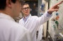David Lacy speaks with chemistry PhD student Paul Fanara in the lab. 