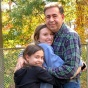 Gina Carbone (center) and her younger sister hug their dad. 