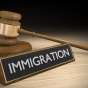 Concept of immigration and the law, a judge's gavel and a sign reading "immigration.". 