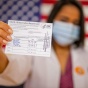 Picture of a doctor showing a Covid Vaccine card. 