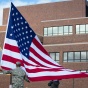 A flag is raised at Flint Loop in front of Capen Hall on North Campus. 