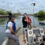 Students on boat with scientific equipment. 