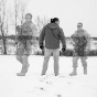 Photo-illustration of two soldiers and one person in black and white looking at the sky. 