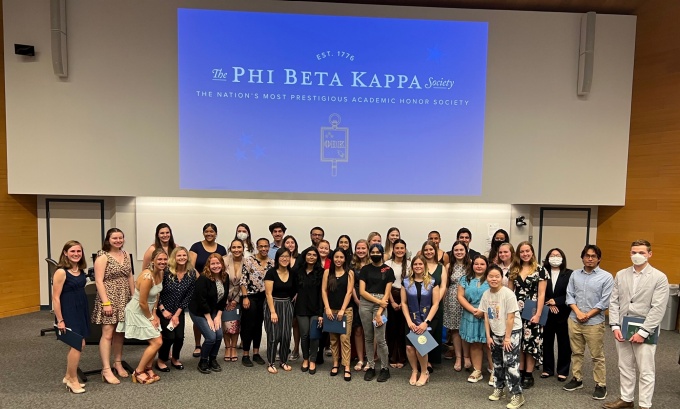 Group photo of 2022 student inductees standing at the front of a classroom. 