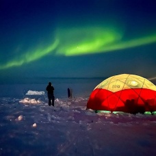 Northern lights over a camp site. 