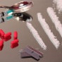 A variety of illicit drugs including pills and white powder and equipment such as syringes, a spoon and razor blades. 