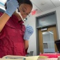Undergraduate researcher Sophia Jacobs measures with a pipette in a lab. 