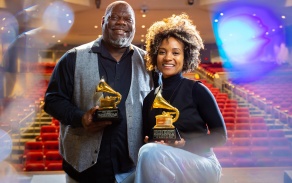 two people posing with grammys. 