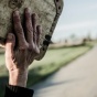 Hand holding up an old case with open road in background. 