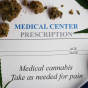 Concept of cannabis for pain management featuring a prescription pad , a stethoscope and dried cannabis buds. 