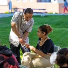 A professor demonstrates an activity for a student. 