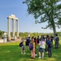 group of students standing outside next to Baird Point with guide. 