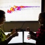 Diana Aga (left) and her PhD student Mindula Wijayahena analyze a chromatogram and an ion mobility separation of PFOS that demonstrates the bacteria's biodegradation of a forever chemical. 