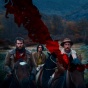 Promotional image for the 2023 film, "The Settlers" featuring three people riding horses. 