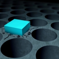 Bright blue cube stands out among rows of dark circular holes. 