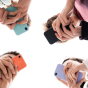 A group of students stands in a circle viewed from below, each holding a smartphone with colorful cases, their hands meeting toward the center against a bright white background. 