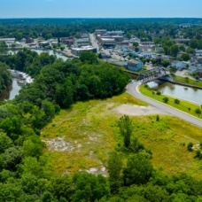 Aerial view of open green space along the Erie Canal in Medina, New York, where a planned public greenspace initiative will be located near the Tonawanda Band of Seneca Nation. 